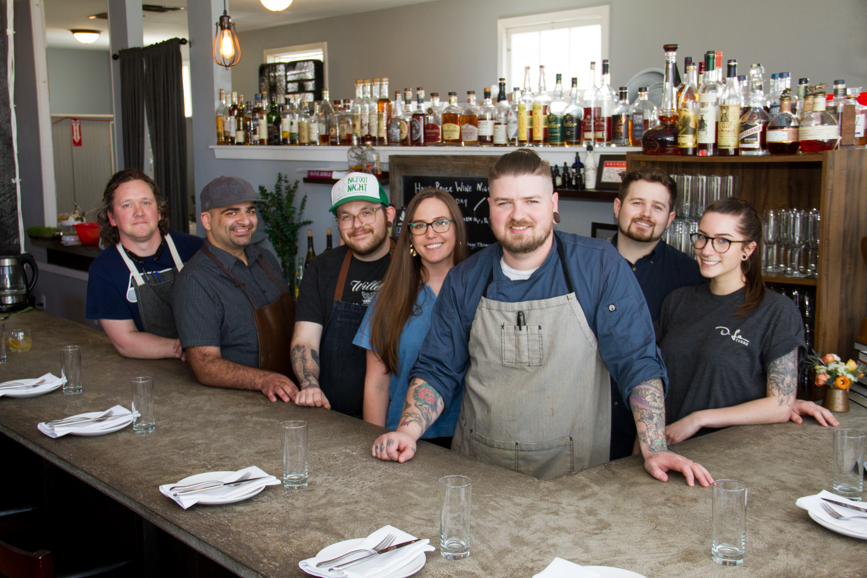 The De La Terre Team poses behind the bar for a group photo.