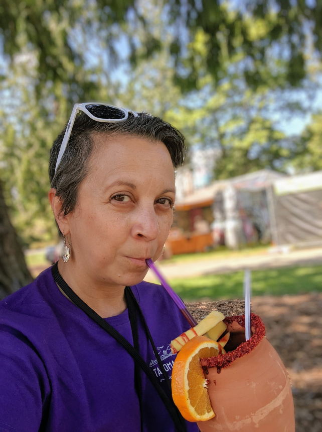 Kris sipping a fruit-topped beverage